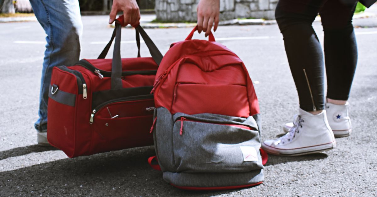 Two travellers carrying soft, packable bags